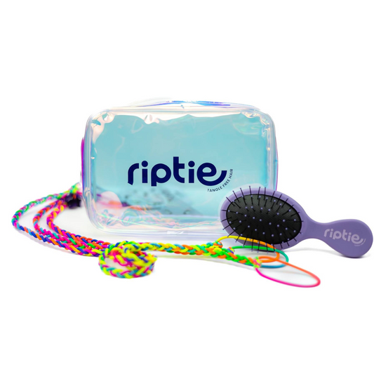 A set of multicolored tie-dye hair ties with a detangling brush and an iridescent gift bag