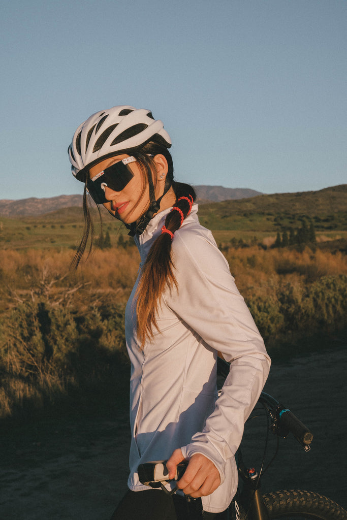 Woman with red wrap around ponytail hair tie with bike helmet and mountain bike