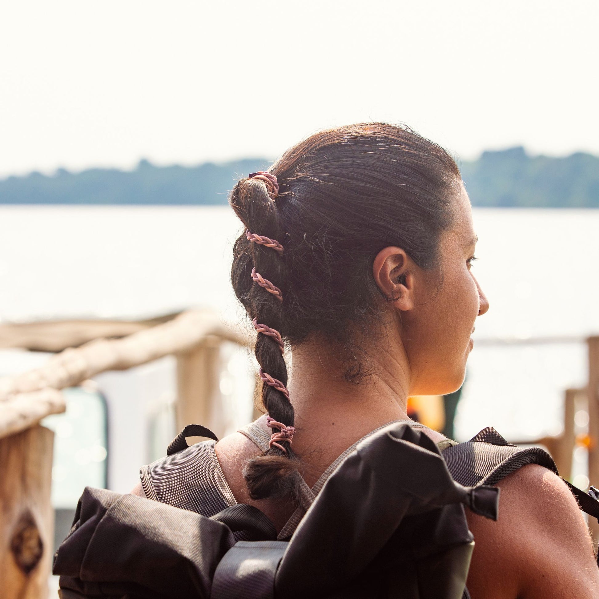 Woman wearing pink hair tie with backpack outdoors