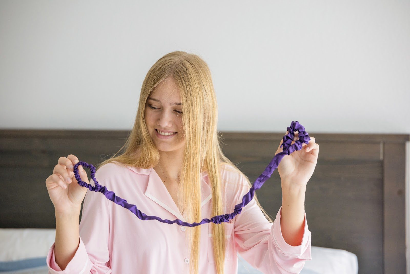 Smiling girl in pink pajamas holding a Midnight Haze Slumber tie